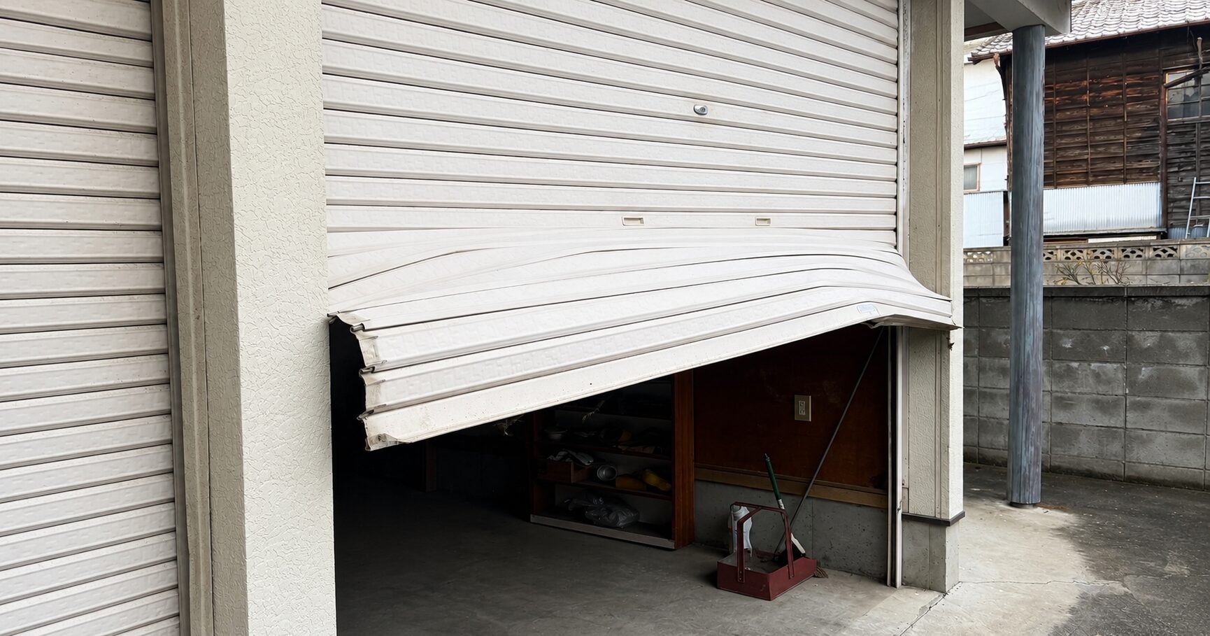 シャッターに車をぶつけてしまいシャッターが歪んでしまった状態